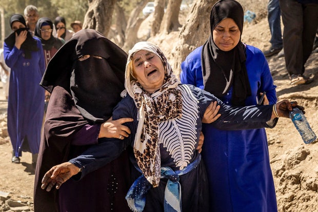 A woman is helped as she reacts to the death of relatives in an earthquake in the mountain village of Tafeghaghte, southwest of Marrakech, on September 10, 2023.