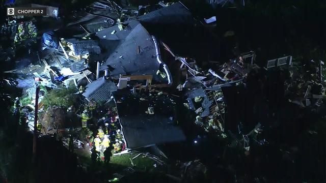 Firefighters search through the collapsed rubble of a home in West Milford. 