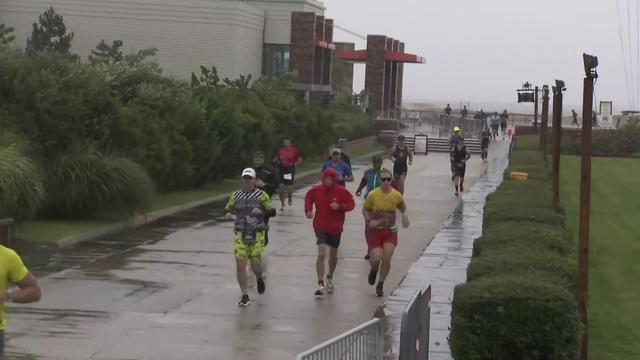 Ironman Triathlon participants run through the rain at Jones Beach State Park. 
