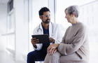 Doctor and patient in conversation, looking at digital tablet 