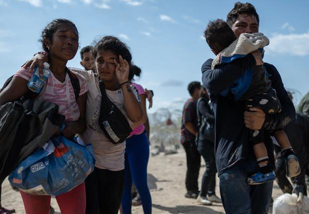 A migrant family from Venezuela reacts after breaking through a razor wire barricade into the United States after waiting for hours on a river bank on the Rio Grande in Eagle Pass, Texas, on Sept. 25, 2023.  