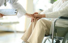 Doctor examining patient in wheelchair 