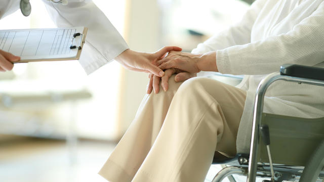 Doctor examining patient in wheelchair 