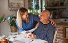 Caregiver or healthcare worker visiting senior man at home. 