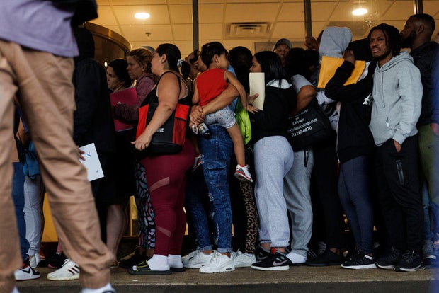 A group of migrants and members of the public wait in line outside an Illinois Department of Human Services office on Sept. 25, 2023, in Chicago.