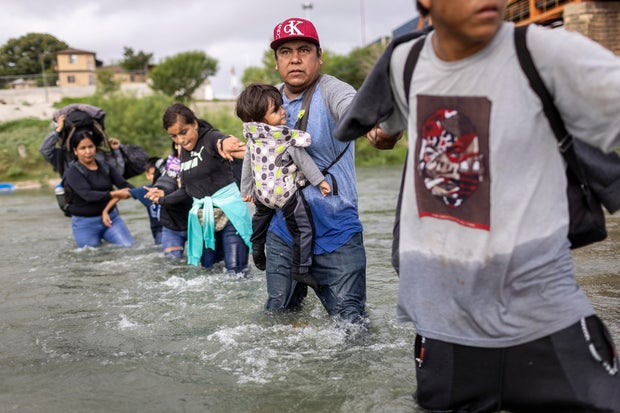 Immigrants from Venezuela cross the Rio Grande from Mexico into the U.S. on Sept. 30, 2023, in Eagle Pass, Texas.