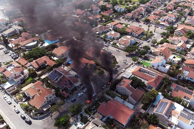 An aerial view shows vehicles on fire during a rocket attack from the Gaza Strip, in Ashkelon, southern Israel, October 7, 2023.