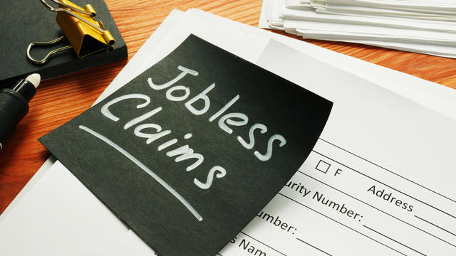 Jobless claims memo stick and pile of documents. 