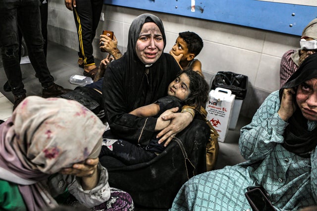 Wounded Palestinians sit in al-Shifa hospital on October 17, 2023, in Gaza City after arriving from al-Ahli hospital following an explosion there. Photo by Abed Khaled/AP.