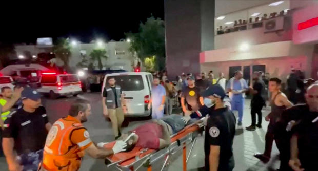 Injured people are taken into hospital after hundreds of Palestinians were killed in a blast at Al-Ahli hospital in Gaza that Israeli and Palestinian officials blamed on each other 