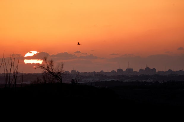 The sun sets over the Gaza Strip as seen from the Israeli side of the border, in southern Israel, Oct. 20, 2023.