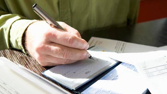 Closeup of man writing out a check 