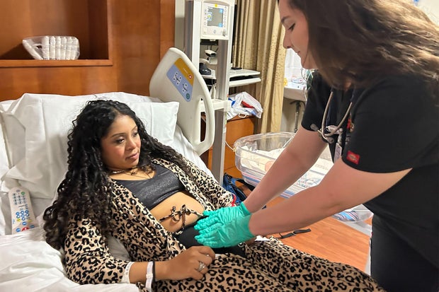 Medical student Mackenzie Hattabaugh checks on a patient