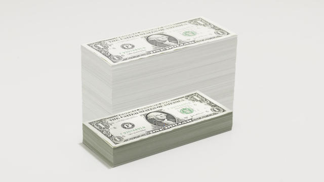 A growing pile of dollar bills 