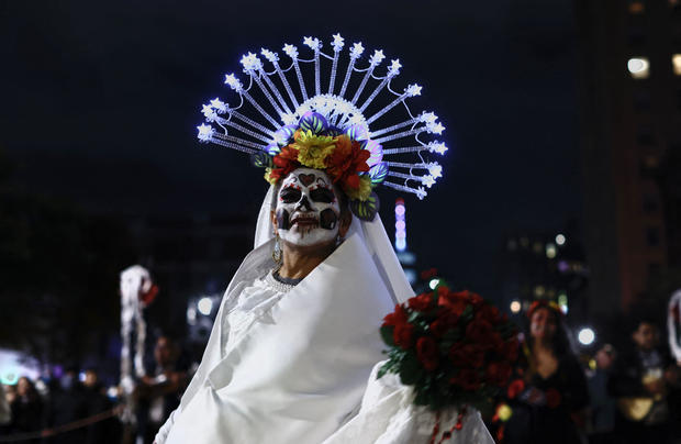 A woman dressed as La Catrina attends the Annual Village Halloween parade in New York on October 31, 2023. 