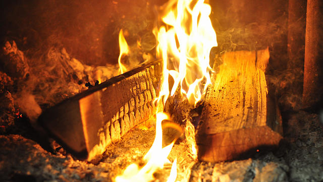 logs and woods are burning with a large fire on the ashes and coals in the stove. fire close-up 