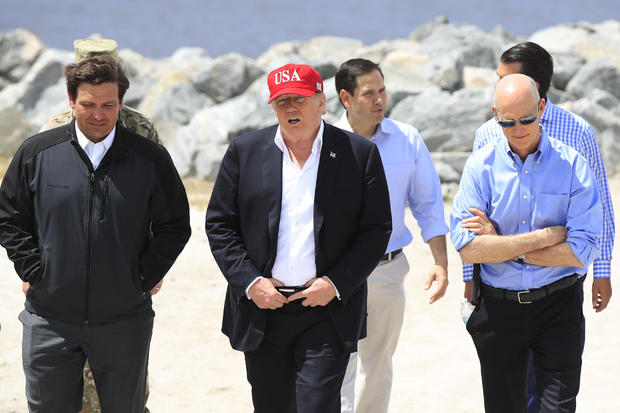 President Donald Trump walks with Florida Gov. Ron DeSantis, Sen. Marco Rubio and Sen. Rick Scott during a visit to Canal Point, Florida, on Friday, March 29, 2019. 