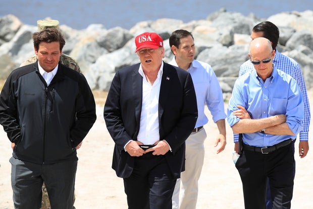 President Donald Trump walks with Florida Gov. Ron DeSantis, Sen. Marco Rubio and Sen. Rick Scott during a visit to Canal Point, Florida, on Friday, March 29, 2019.