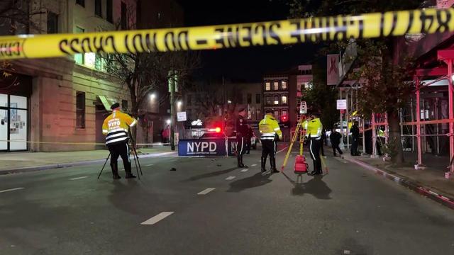 NYPD officers examine a crime scene. 