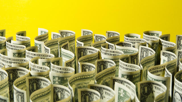 Sea of US 1 dollar bills on yellow background 