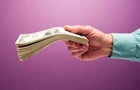 Man's hand holding stack of cash 