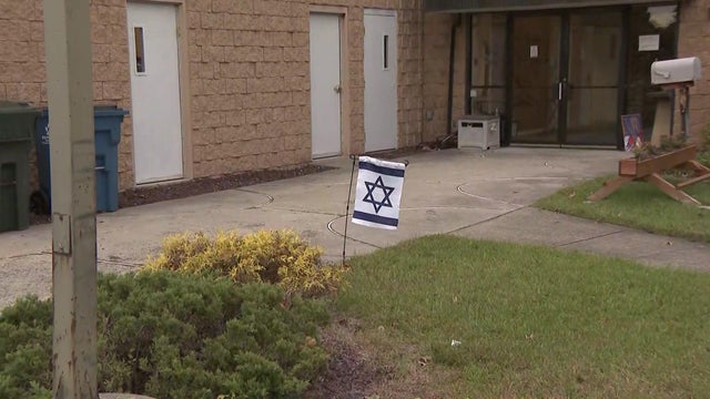 The exterior of the Monroe Township Jewish Center, including an Israeli flag stuck in the ground. 