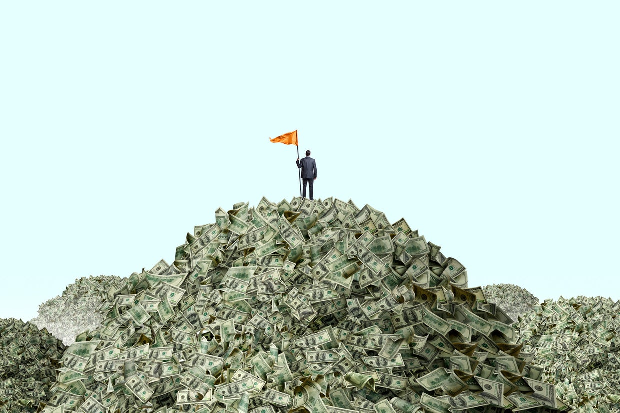Man Planting Flag On Piles Of Cash 