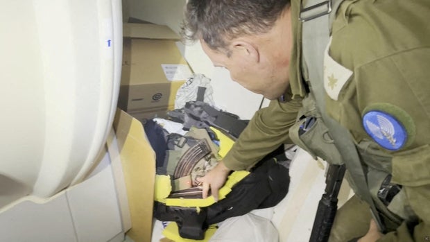 An Israeli officer points at what he describes as a grab bag containing a rifle and other munitions belonging to a Hamas fighter that was discovered behind an MRI machine at the Al-Shifa hospital complex in Gaza City, Nov. 15, 2023