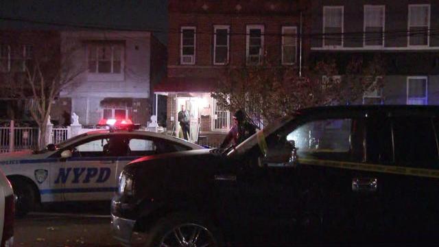 An NYPD vehicle is parked outside a Brooklyn home. Crime scene tape blocks off the street. 