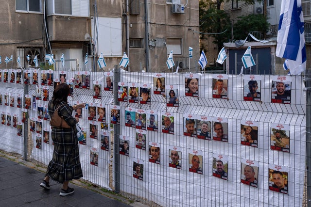 A woman looks at photographs of hostages who were abducted during the Oct. 7 Hamas attack on Israel,