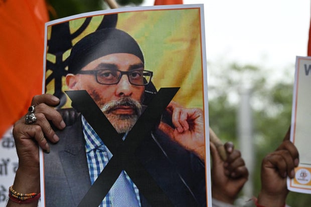 A member of the United Hindu Front organization holds a banner depicting Gurpatwant Singh Pannun, a lawyer and activist designated as a terrorist by the Indian government, during a protest in New Delhi, India, Sept. 24, 2023