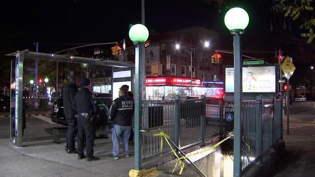 Police stand outside an entrance to the Ralph Avenue subway station, which has been blocked off by crime scene tape. 