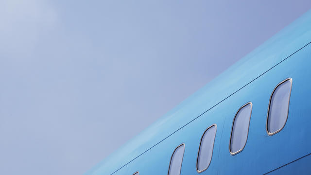 Windows of a Bright Blue Airplane against the Sky 