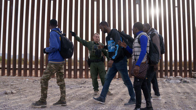A U.S. Customs and Border Protection officer directs migrants at the US-Mexico border in Lukeville, Arizona, US, on Monday, Dec. 11, 2023. 