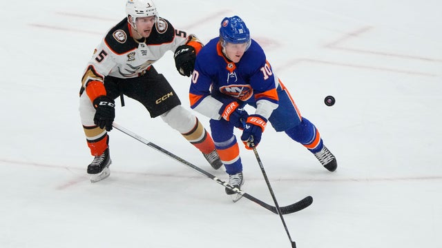 Anaheim Ducks Defenseman Urho Vaakanainen (5) and New York Islanders Right Wing Simon Holmstrom (10) battle for the puck during the first period of the National Hockey League game between the Anaheim Ducks and New York Islanders on December 13, 2023, at U