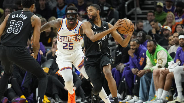 Brooklyn Nets forward Mikal Bridges (1) looks to pass as Phoenix Suns forward Nassir Little (25) defends during the first half of an NBA basketball game, Wednesday, Dec. 13, 2023, in Phoenix. 
