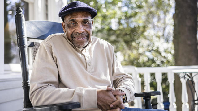 Senior man in rocking chair on front porch 