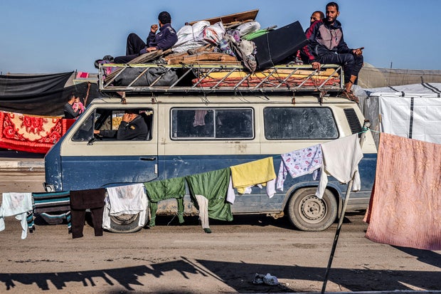 A minibus carrying people fleeing from the central Gaza Strip with their belongings arrives in Rafah in the southern Gaza Strip following an evacuation order on Dec. 26, 2023