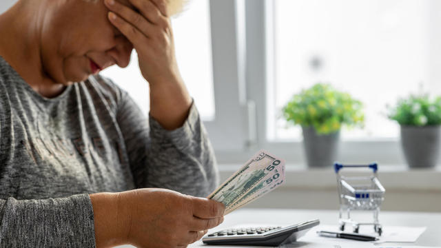 Worried woman looking on bills while at home 