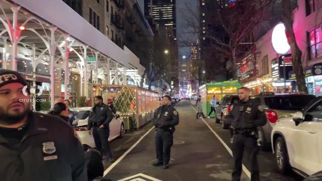 NYPD officers stand on a New York City street. 