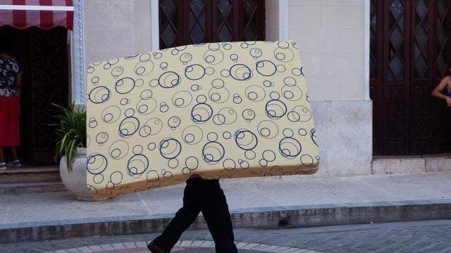 A man carrying a mattress
