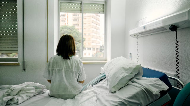 sick woman alone in a hospital room
