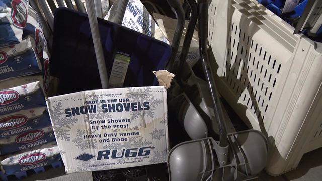 Snow shovels and salt on display inside a store. 