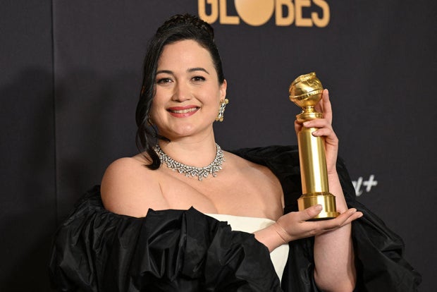 Lily Gladstone posing with the Golden Globe Award