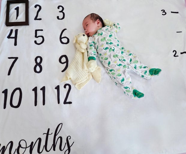 Baby Emory lies on a blanket