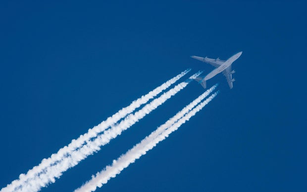Jet plane in flight, leaving contrails behind