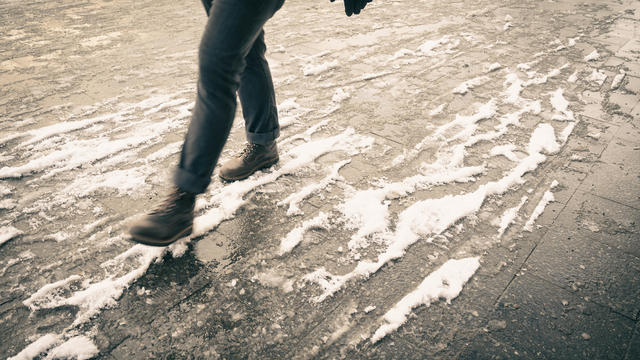 Unrecognizable person walking down the street in a snowy day. Berlin, Germany. 