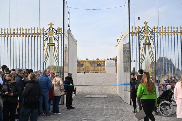 Visitors wait to enter the Palace of Versailles after it was evacuated due to a bomb threat, in Versailles, France, Oct. 17, 2023