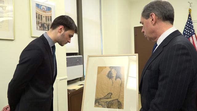 Paul Reif and his father, Timothy, look at the framed art piece "Girl with Black Hair." 