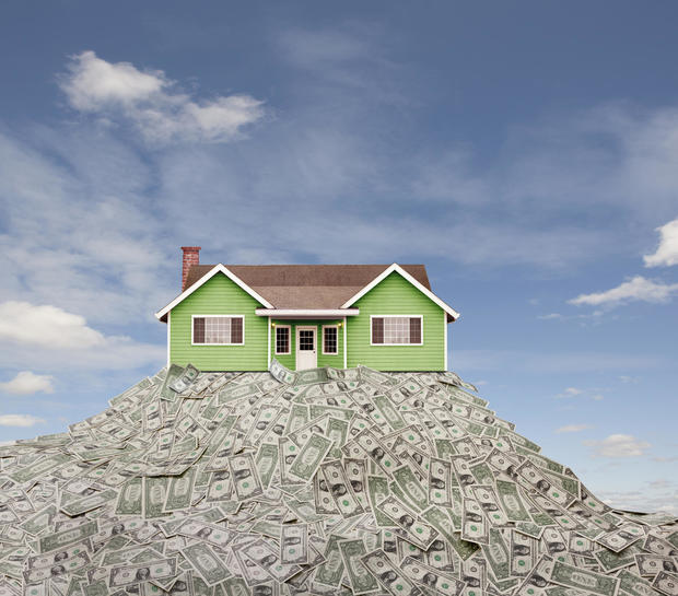 House sitting on pile of dollar bills 